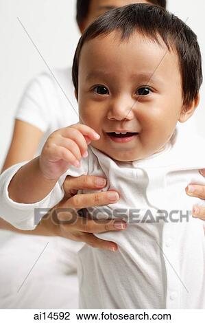 Stock Image - Baby boy looking at camera, smiling. Fotosearch