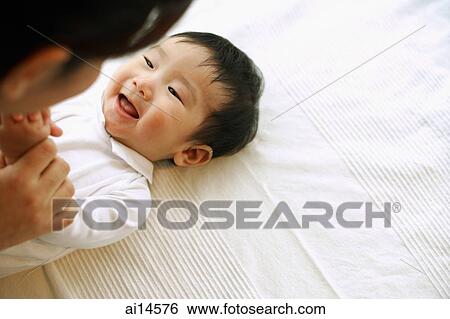 Baby boy lying down, looking up at mother View Large Photo Image Stock Photograph - Baby boy lying down, looking up at mother. Fotosearch