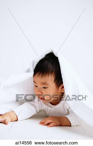 Stock Photograph - Baby boy lying on front, under blanket. Fotosearch