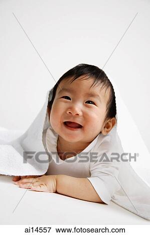 Stock Photo - Baby boy peeking out from under blanket. Fotosearch