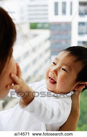 Baby boy touching mother's face View Large Photo Image Stock Image - Baby boy touching mother's face. Fotosearch