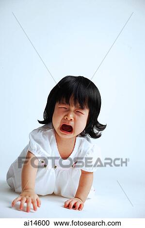 Stock Image - Baby girl crawling on floor, crying, mouth open. Fotosearch