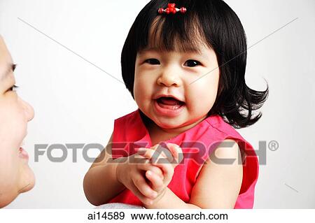 Baby girl smiling, mother looking at her View Large Photo Image Stock Photo - Baby girl smiling, mother looking at her. Fotosearch