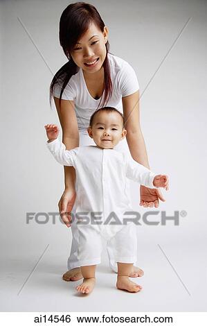Baby girl standing, mother behind her, portrait View Large Photo Image Stock Photograph - Baby girl standing, mother behind her, portrait. Fotosearch