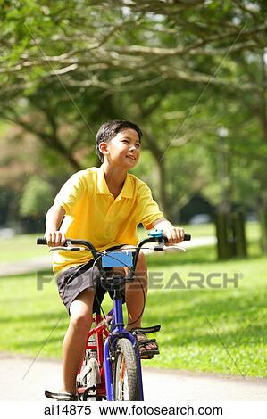 Stock Photography - Boy in park, cycling. Fotosearch