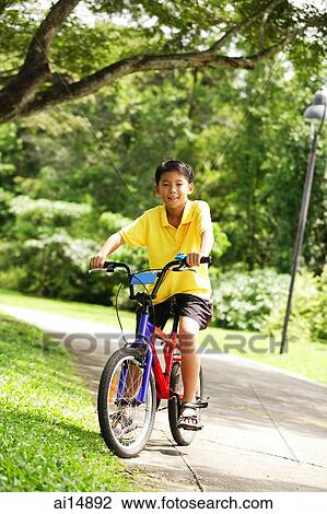 Boy on bicycle, looking at camera View Large Photo Image Stock Image - Boy on bicycle, looking at camera. Fotosearch