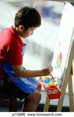 Boy sitting in front of easel, painting View Large Photo Image Stock Photograph - Boy sitting in front of easel, painting. Fotosearch