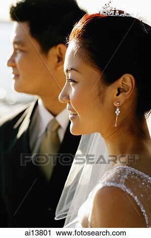 Stock Image - Bride and groom looking away. Fotosearch