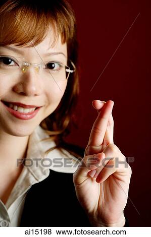 Business woman, fingers crossed, looking at camera View Large Photo Image Stock Photo - Business woman, fingers crossed, looking at camera. Fotosearch