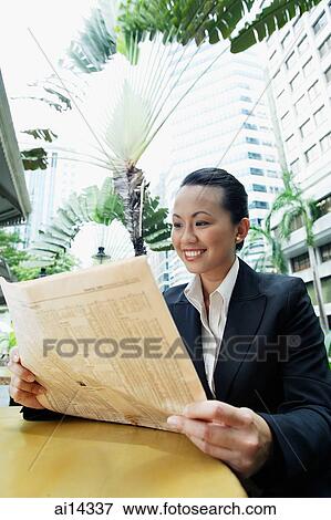 Stock Photo - Business woman reading newspaper. Fotosearch