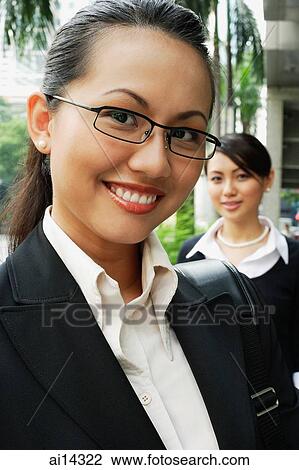 Business woman, smiling, looking at camera, people in the background View Large Photo Image Stock Image - Business woman, smiling, looking at camera, people in the background. Fotosearch