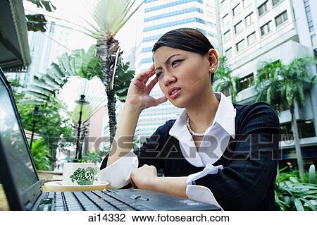 Business woman using laptop, frowning, hand on head View Large Photo Image Stock Image - Business woman using laptop, frowning, hand on head. Fotosearch