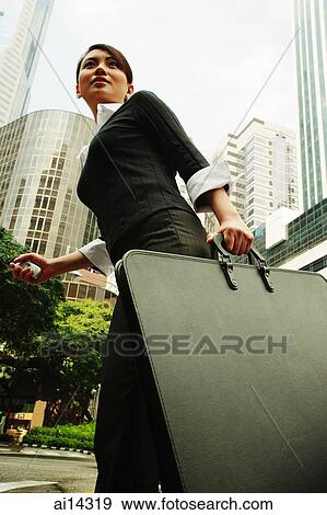 Business woman walking with briefcase, buildings in the background View Large Photo Image Stock Photo - Business woman walking with briefcase, buildings in the background. Fotosearch