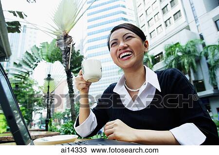 Business woman with laptop, holding coffee cup, smiling View Large Photo Image Stock Image - Business woman with laptop, holding coffee cup, smiling. Fotosearch