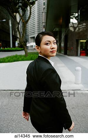 Business women walking, turning to looking at camera View Large Photo Image Stock Photography - Business women walking, turning to looking at camera. Fotosearch
