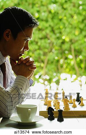 Picture - Businessman contemplating chess board. Fotosearch