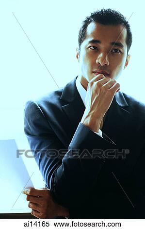 Stock Photography - Businessman holding document, arms crossed and hand on chin. Fotosearch
