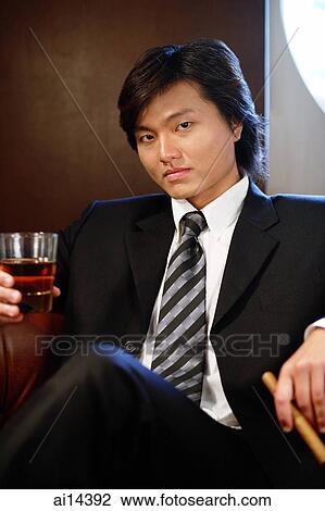 Businessman holding glass and cigar, looking at camera, portrait View Large Photo Image Stock Image - Businessman holding glass and cigar, looking at camera, portrait. Fotosearch