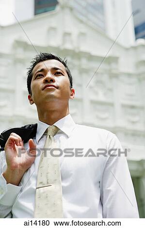 Businessman holding jacket over shoulder, looking away View Large Photo Image Stock Image - Businessman holding jacket over shoulder, looking away. Fotosearch