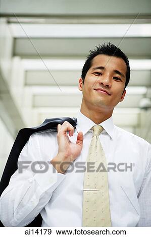 Businessman holding jacket over shoulder, looking at camera View Large Photo Image Stock Photo - Businessman holding jacket over shoulder, looking at camera. Fotosearch