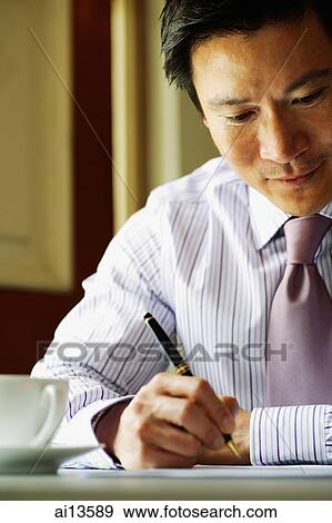 Businessman holding pen and writing View Large Photo Image Stock Photo - Businessman holding pen and writing. Fotosearch