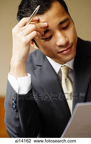 Businessman looking at document, hand on head View Large Photo Image Stock Image - Businessman looking at document, hand on head. Fotosearch