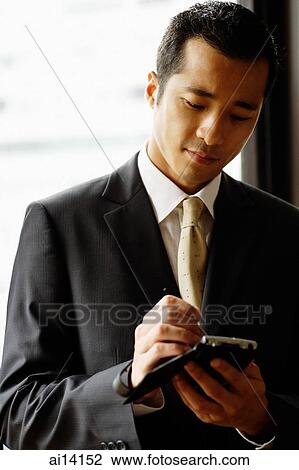 Stock Image - Businessman looking at PDA. Fotosearch