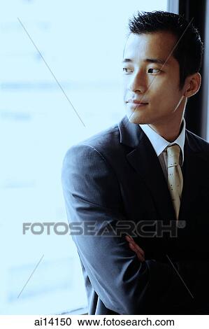 Stock Image - Businessman looking away, arms crossed. Fotosearch