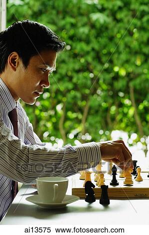 Businessman making a move in chess game View Large Photo Image Stock Photography - Businessman making a move in chess game. Fotosearch