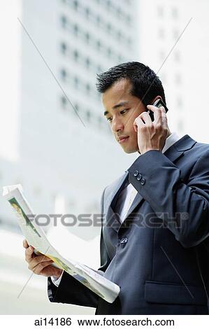 Businessman on the phone, holding newspaper View Large Photo Image Stock Photograph - Businessman on the phone, holding newspaper. Fotosearch
