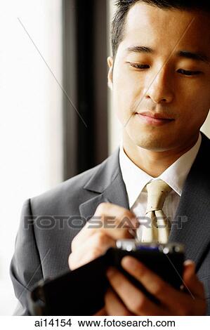 Businessman using PDA View Large Photo Image Picture - Businessman using PDA. Fotosearch