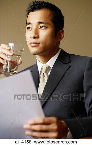 Businessman with document and glass of water View Large Photo Image Stock Photo - Businessman with document and glass of water. Fotosearch
