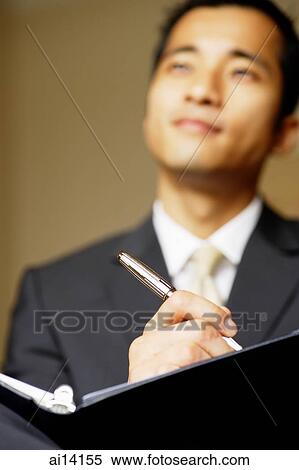 Businessman with folder and pen, low angle view View Large Photo Image Stock Photography - Businessman with folder and pen, low angle view. Fotosearch
