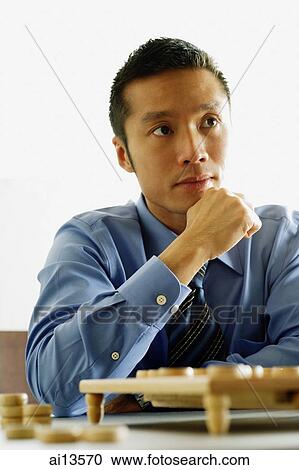 Businessman with hand on chin View Large Photo Image Stock Image - Businessman with hand on chin. Fotosearch