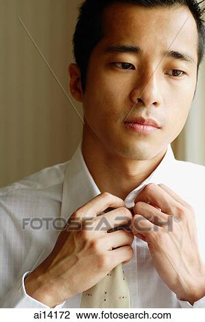 Stock Image - Businessman with hand on collar and tie. Fotosearch