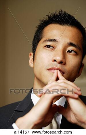 Businessman with hands clasped, fingers on mouth View Large Photo Image Stock Photo - Businessman with hands clasped, fingers on mouth. Fotosearch