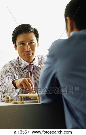 Businessmen playing chess, over the shoulder view View Large Photo Image Stock Photo - Businessmen playing chess, over the shoulder view. Fotosearch