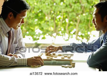 Stock Image - Businessmen playing chess. Fotosearch