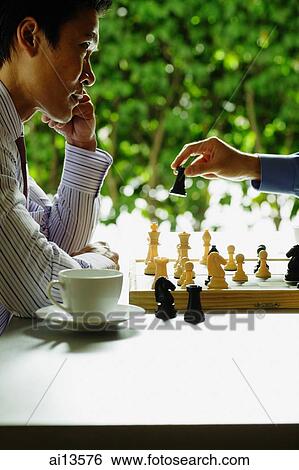 Businessmen playing chess, teacup and saucer next to one of them View Large Photo Image Stock Photograph - Businessmen playing chess, teacup and saucer next to one of them. Fotosearch