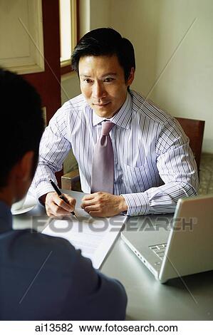 Businessmen talking, laptop open on the table View Large Photo Image Stock Image - Businessmen talking, laptop open on the table. Fotosearch