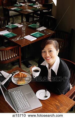 Businesswoman holding cup, smiling at camera View Large Photo Image Stock Image - Businesswoman holding cup, smiling at camera. Fotosearch