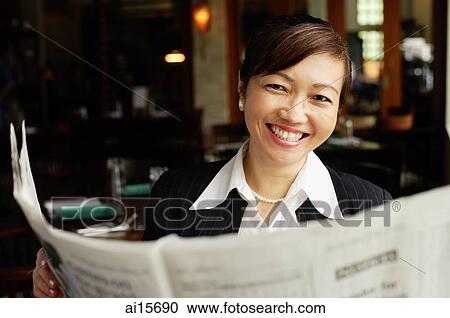 Businesswoman holding newspaper, smiling View Large Photo Image Stock Image - Businesswoman holding newspaper, smiling. Fotosearch