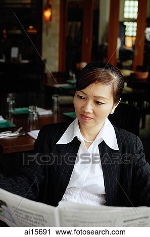 Businesswoman in restaurant, reading newspaper View Large Photo Image Stock Image - Businesswoman in restaurant, reading newspaper. Fotosearch