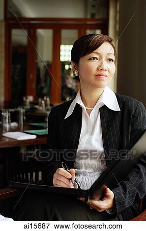 Businesswoman, sitting, holding pen and folder, looking away, View Large Photo Image Stock Photo - Businesswoman, sitting, holding pen and folder, looking away,. Fotosearch