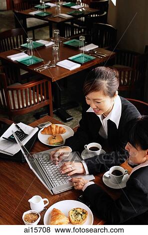 Stock Photo - Businesswomen at cafe, using laptop. Fotosearch