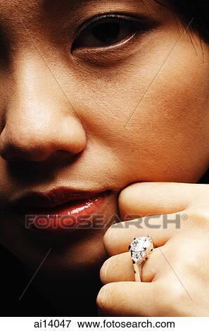 Close up of young woman's face and hand with ring on finger View Large Photo Image Stock Photo - Close up of young woman's face and hand with ring on finger. Fotosearch