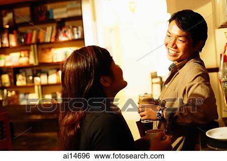 Couple at bar counter, talking, man smiling View Large Photo Image Stock Photograph - Couple at bar counter, talking, man smiling. Fotosearch