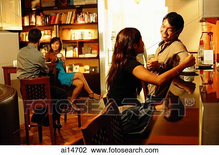 Couple at bar counter, talking, people in the background View Large Photo Image Stock Image - Couple at bar counter, talking, people in the background. Fotosearch