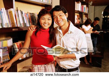 Couple at bookstore, looking at camera, portrait View Large Photo Image Stock Image - Couple at bookstore, looking at camera, portrait. Fotosearch