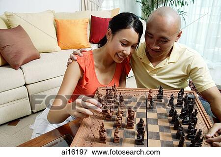 Couple at home in living room, playing chess View Large Photo Image Stock Photo - Couple at home in living room, playing chess. Fotosearch